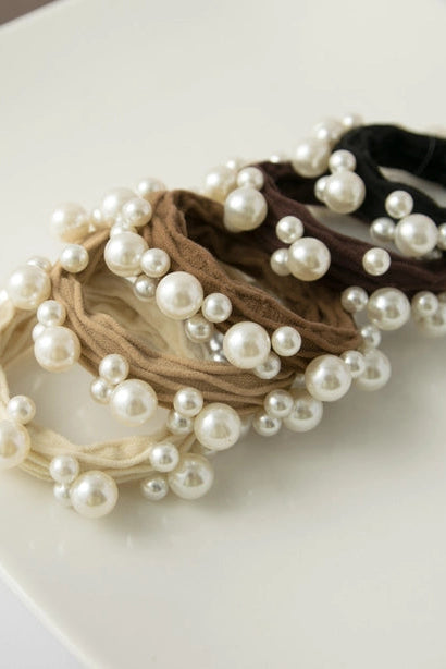 Set of pearl embellished hair ties on a white surface