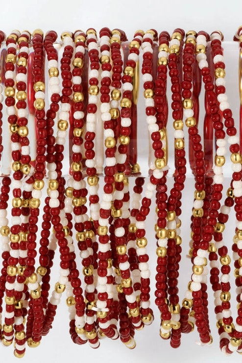 A bulk set of beaded bangles featuring alternating red and white beads with small metallic gold accents, displayed hanging against a white background.